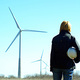Fotolia_7349110_S.jpg (Woman engineer or architect with white safety hat and wind turbines on background)